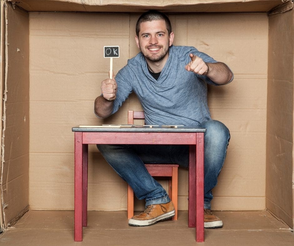 La imagen muestra a un adulto en una caja con actitud positiva lo cual es fundamental para mejorar la autoestima